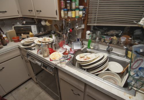 Dirty dishes piled up in sink after a party